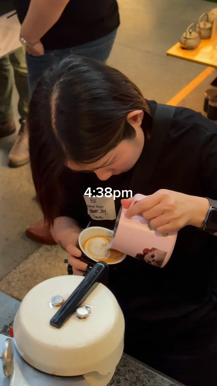 Draft frame from the barista battle reel: a barista pours latte art into a cup, with 4:38pm on screen