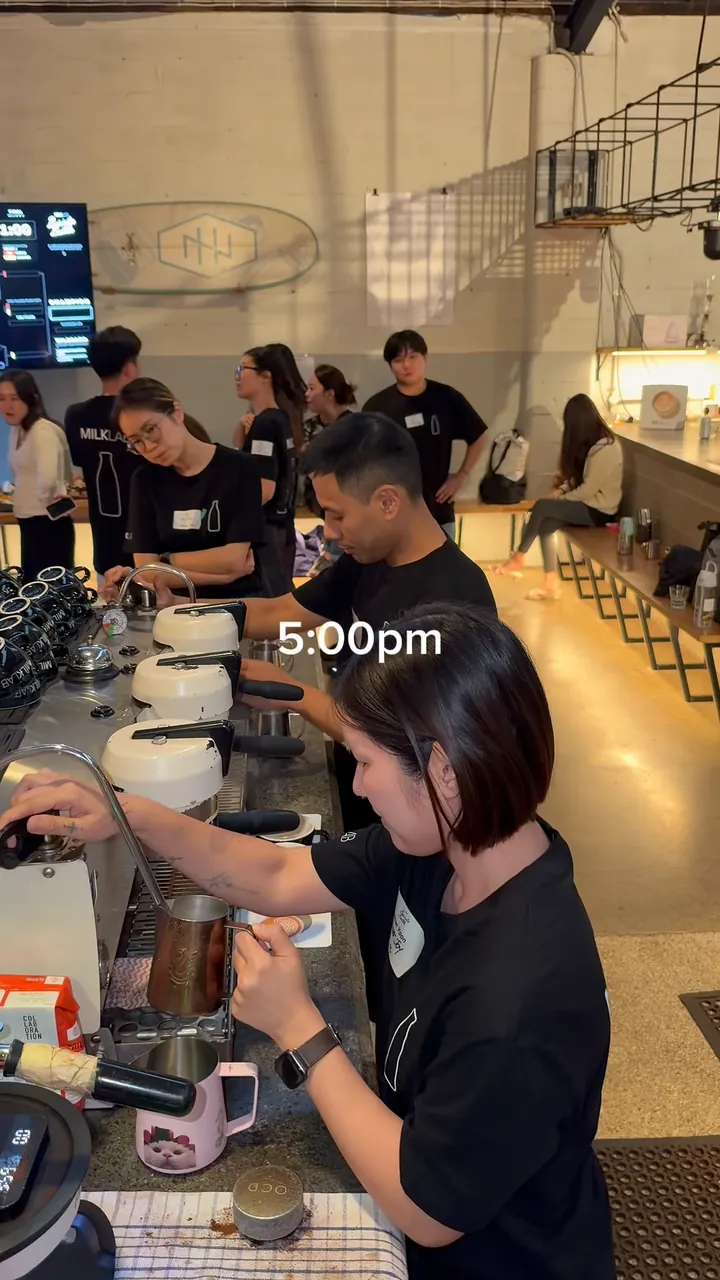 Draft frame from the barista battle reel: a barista works at the competition machines, with 5:00pm on screen