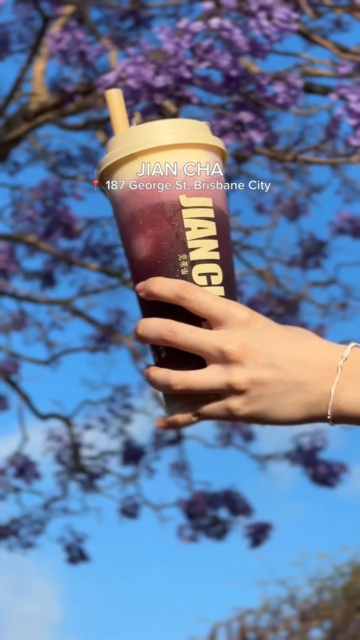Jacaranda reel end card: a Jian Cha cup held up under jacaranda flowers, with JIAN CHA and 187 George St, Brisbane City on screen