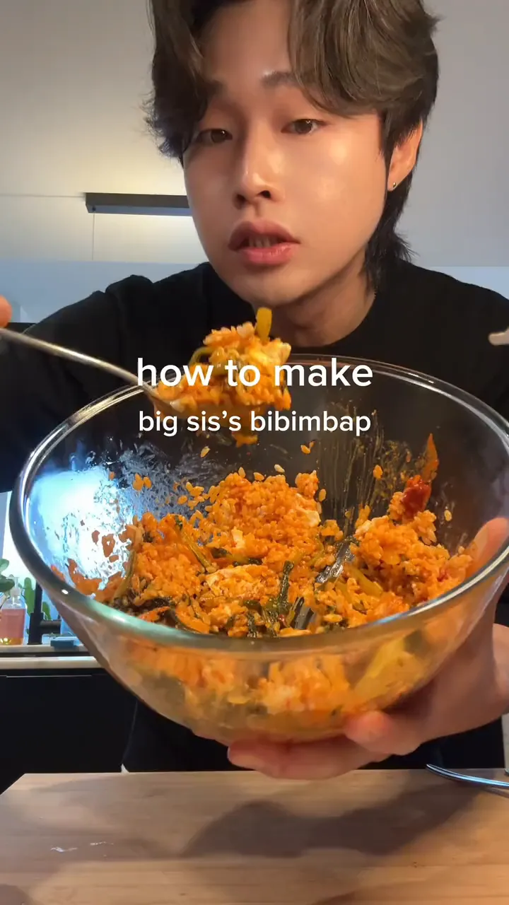 MJ eats bibimbap from a glass bowl, then builds it from rice, fried eggs and young radish kimchi.